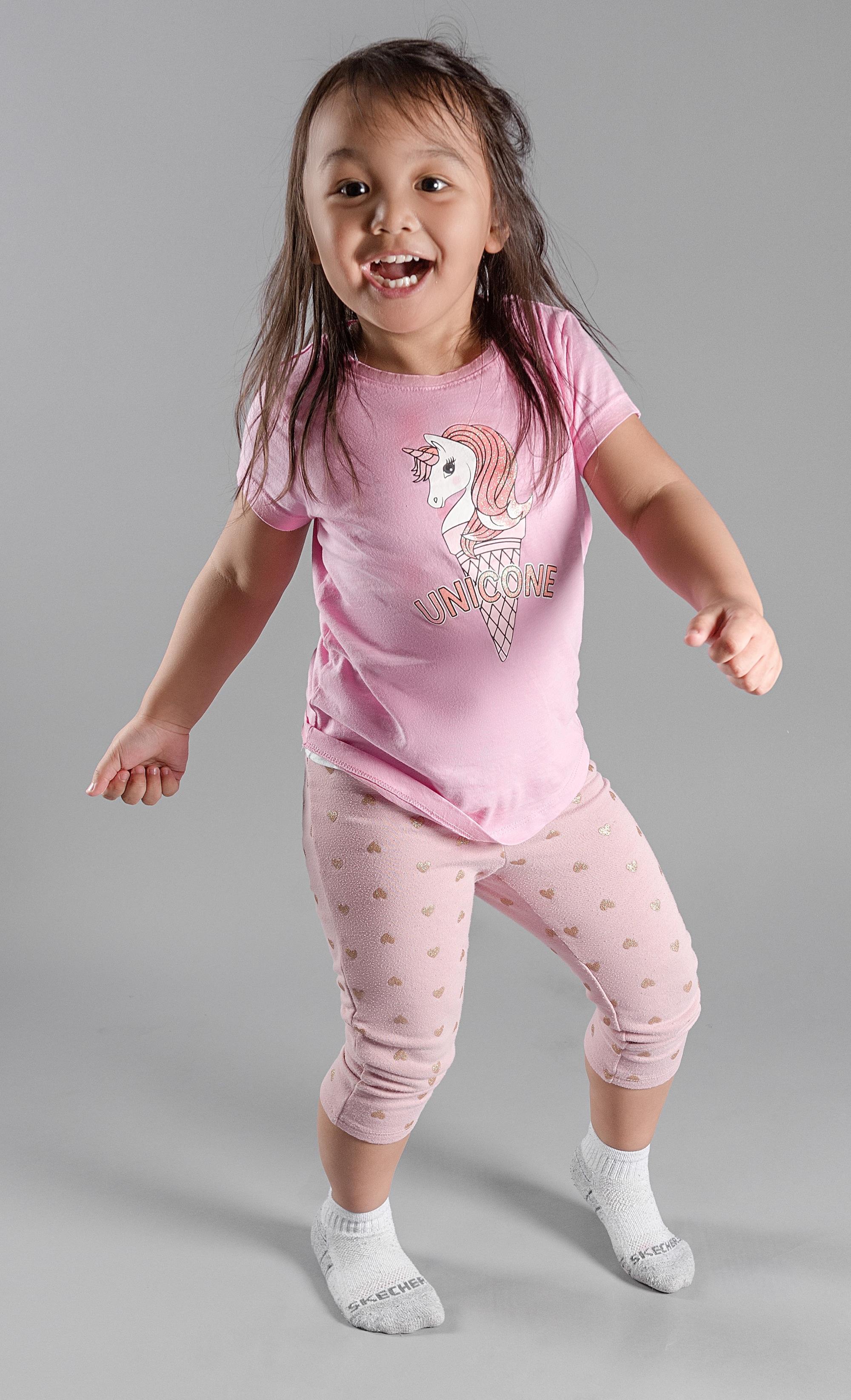 a little girl in pajamas dances and laughs