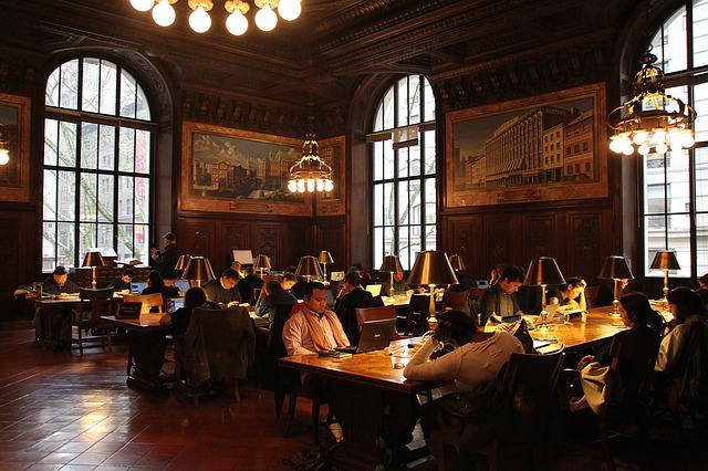 people studying at tables in a public library