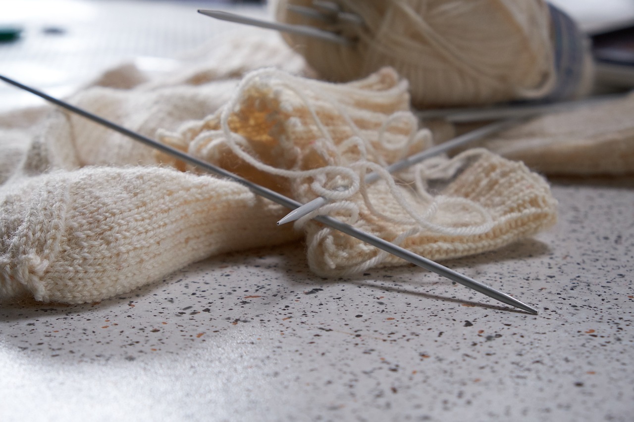 partially finished scarf with knitting needles.